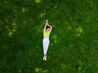 Wall Mural - overhead view of woman laying down on green grass