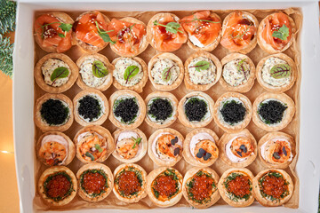 Wall Mural - Black and Red caviar with butter in tartlets, crispy shrimps with lemon in sauce in take way box. Menu food for delivery in the Coronavirus Pandemic