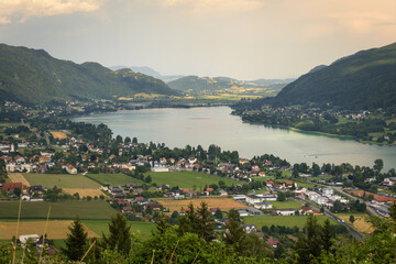 Panoramic view of the town of Pörtschach am Wörther See beside Wörthersee lake on a cloudy day in summer, Austria