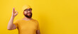 © alesmunt - smiling bearded man in glasses showing ok gesture over yellow background, panoramic layout