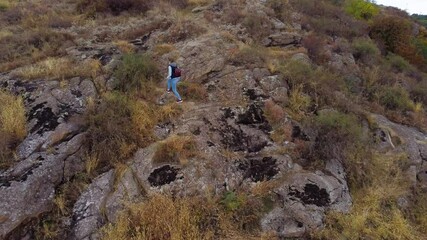 Wall Mural - Young Woman Hiking on the Rocky Trail in the Autumn Mountains.