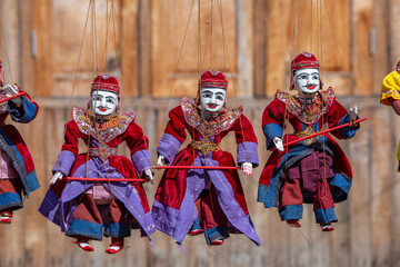 Wall Mural - Colorful puppets in a tourist stall on the street market in Burma, Myanmar. Handmade dolls hanging on display store