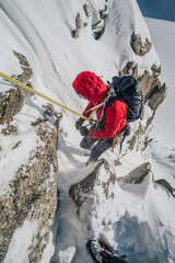 Wall Mural - Climber rappeling down an alpine peak. Winter mountaineering, alpinism in Mont Blanc Masiff, France. An alpinist descending on a rope from a mountain.