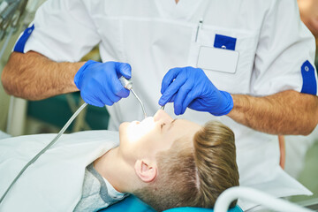 Wall Mural - male dentist at work with young patient