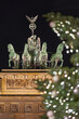 Germany Berlin, Christmas tree in front of illuminated Brandenburg Gate in Berlin City in the evening with dark sky , close up 