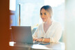 © ManuPadilla - Stylish businesswoman typing on laptop in cafe