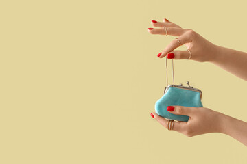 Young woman with beautiful manicure taking necklace out of small purse on color background