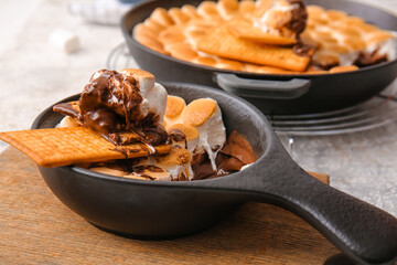 Frying pan with tasty S'mores dip on table, closeup