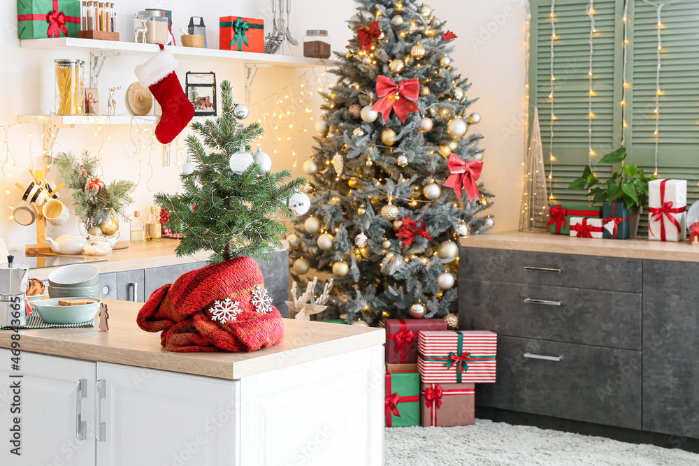 Small Christmas tree on table top in interior of light kitchen