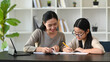 © Prathankarnpap - Happy asian mother helping her daughter doing homework.