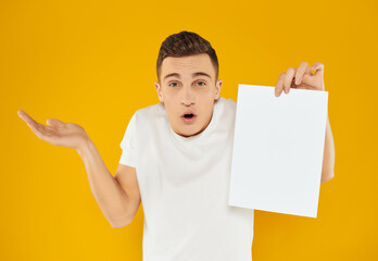 Wall Mural - man with sheet of paper advertising copy space presentation yellow background