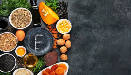 Wall Mural - Foods high in vitamin E on dark background.