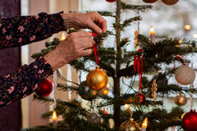 Woman's Hands Decorating Christmas Tree
