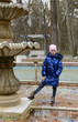 Concept late autumn. Girl stands in dry bowl of fountain