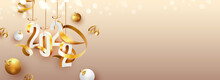 3D 2022 Number Hang With Golden Curl Ribbons And Baubles On Peach Bokeh Background.