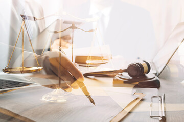 Justice and law concept.Male judge in a courtroom with the gavel, working with, computer and docking keyboard, eyeglasses, on table in morning light