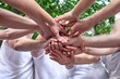 © OneWellStudio - A diverse group of people on corporate teambuilding party. Stacking hands, partners standing outdoors