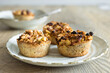 © Tales by Pictures - Horizontal close-up of little home-made apple pies with pieces of apple and raisins on a porcelain plate. Selective focus and copy space