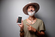 © luengo_ua - Poninting copy space on screen. Studio portrait of handsome senior man using smartphone.