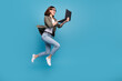 Profile side full size photo of excited lady ceo jump chatting netbook ap wear denim isolated over blue color background