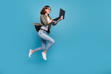Profile side full size photo of excited lady ceo jump chatting netbook ap wear denim isolated over blue color background