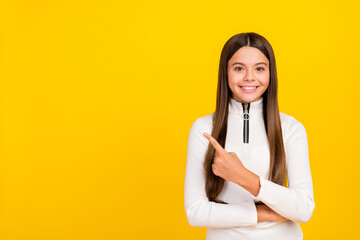 Canvas Print - Photo of adorable cute preteen girl dressed white zipper shirt pointing finger empty space smiling isolated yellow color background