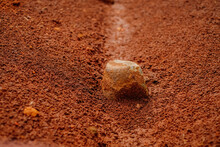 A Stone Lies On Red Soil