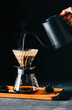 canvas print picture - Alternative coffee brewing method, using pour over dripper and paper filter. Black background