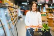 © Serhii - Casual woman grocery shopping and looking happy