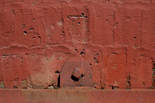 A Single Red Bolt Holds A Window Grate In This Red Painted Old Brick Warehouse