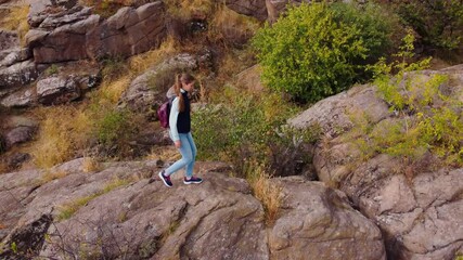 Wall Mural - young woman hiking on the rocky trail in the autumn mountains.