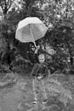 Double Exposure Of Little Kid Holding Up His Umbrella In Rain