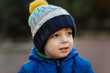 © Cavan Images - Portrait of small boy in garden in blue jacket and warm hat