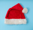 © Miroslav - Santa Clause's hat, flatlay on pastel blue background.