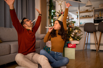 Wall Mural - Young Caucasian love couple having fun together at home, celebrating winter h olidays together, bonding, dancing and smiling