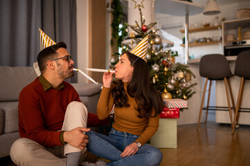 Young Caucasian love couple having fun together at home, celebrating winter h olidays together, bonding, dancing and smiling