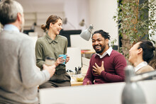 Multi-ethnic Business Team Is Having Fun While Talking On Their Coffee Break In Office.
