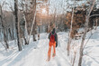 © Maridav - Snowshoeing people in winter forest with snow covered trees on snowy day. Man on hike in snow hiking in snowshoes living healthy active outdoor lifestyle