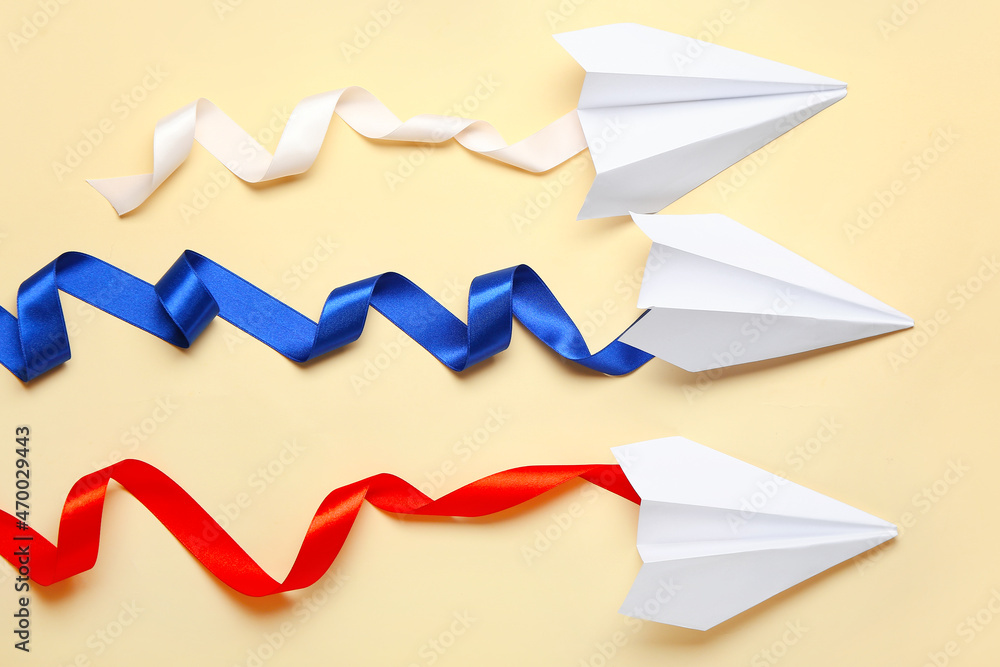 Russian flag concept. Paper planes with ribbons on color background