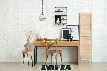 Stylish workplace in room near wall