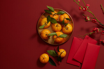 Chinese lunar new year with mandarin orange , flower and red pocket in red background , photography Tet holiday content , top view