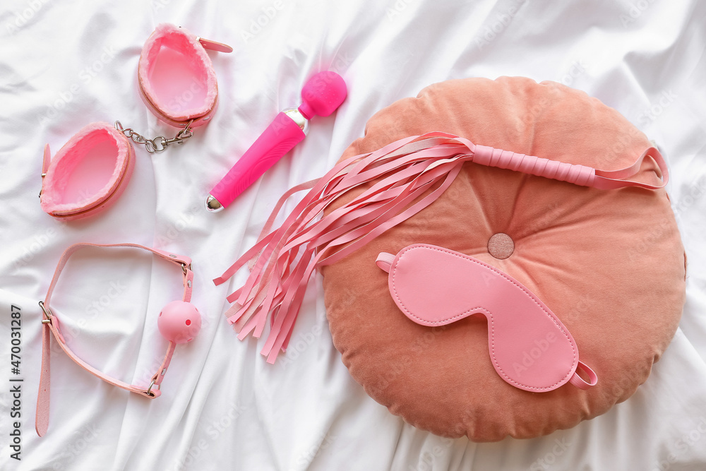 Different BDSM sex toys on bed