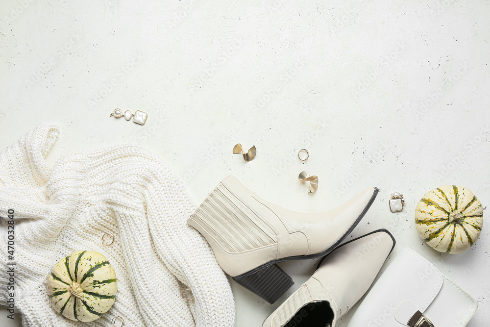 Female shoes, accessories and pumpkins on light background