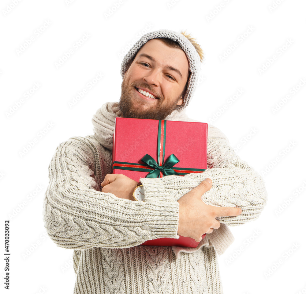 Handsome young man with Christmas gift on white background