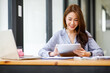 © David - Shot of a asian young business Female working on laptop computer in her workstation.Portrait of Business people employee freelance online marketing e-commerce telemarketing concept.