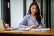 © David - Shot of a asian young business Female working on laptop computer in her workstation.Portrait of Business people employee freelance online marketing e-commerce telemarketing concept.