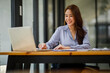 © David - Shot of a asian young business Female working on laptop computer in her workstation.Portrait of Business people employee freelance online marketing e-commerce telemarketing concept.