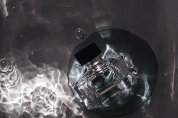 Perfume bottle under water with bubbles. Top view.