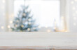 © didecs - Empty wooden table in front of blurred winter festive background