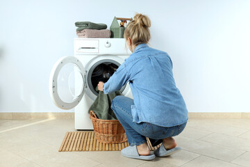 Wall Mural - Concept of housework with washing machine and girl against white wall